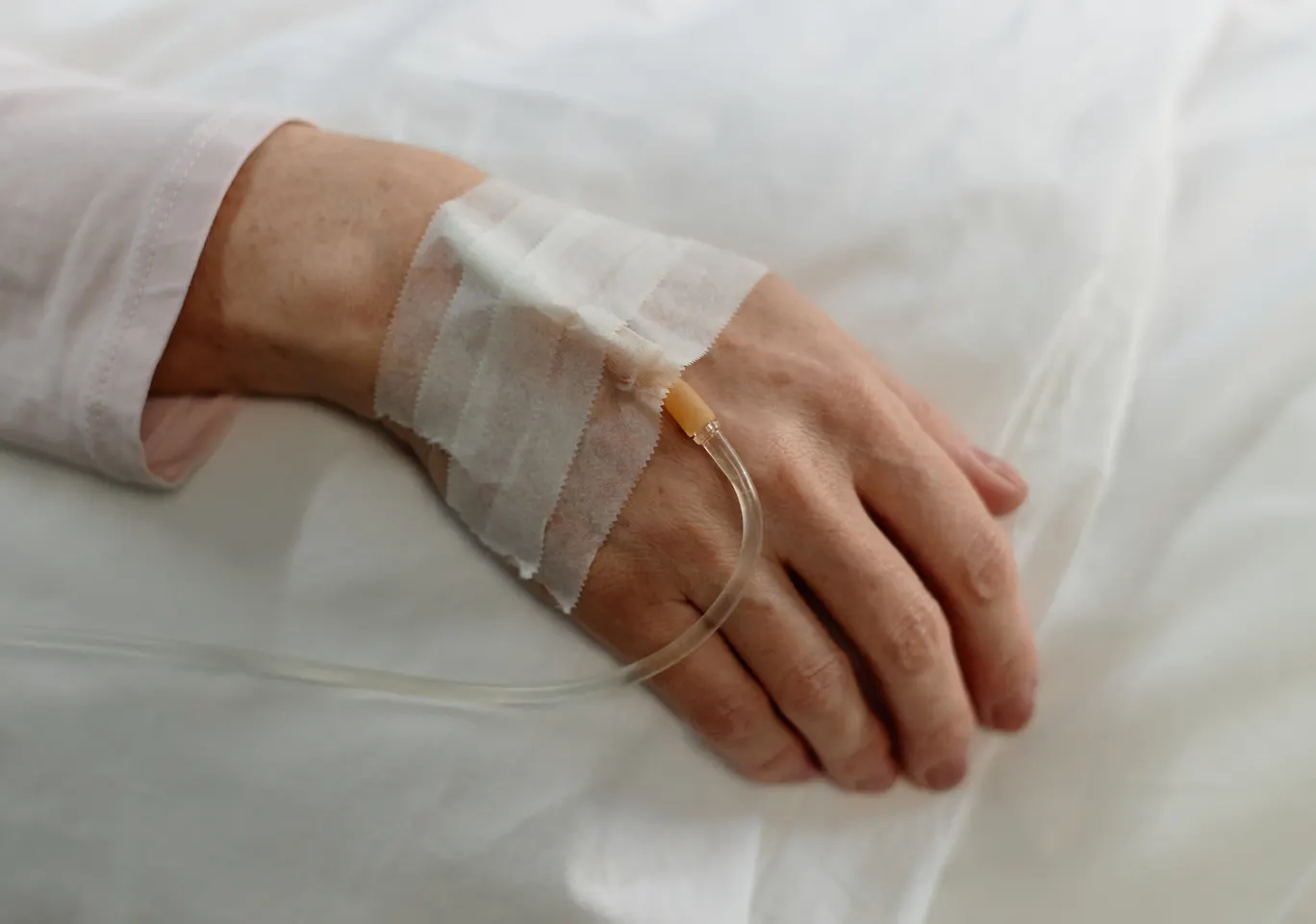 Kroplówki witaminowe Gostynin: dłoń z podłączoną kroplówką w spokojnym kadrze
